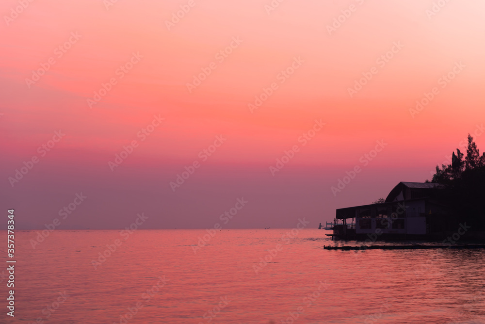 silhouette of fishing boats on lake at sunset