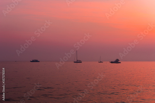 silhouette of fishing boats on lake at sunset © yupachingping