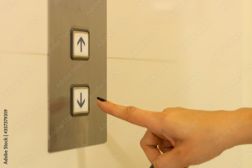 Naklejka premium finger presses the elevator button. hand reaches for the button of the elevator