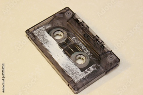 Old audio cassette lehit on a yellow background