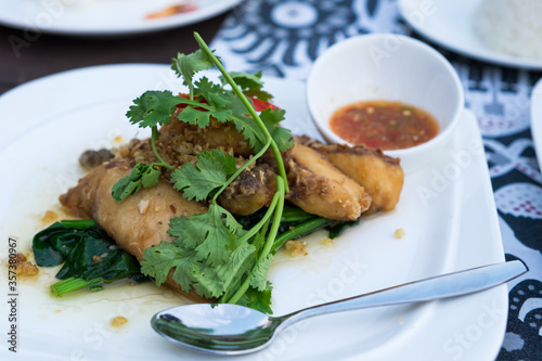 Fried dolly fish with garlic pepper garnish with coriander serve with spicy sauce