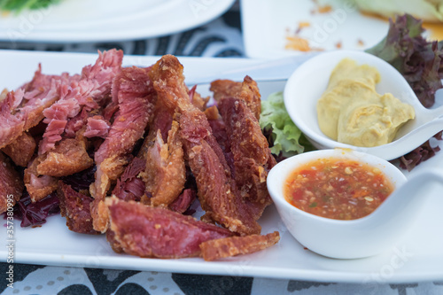 Fried pork knuckle served with seafood sauce and mustard put in spoon