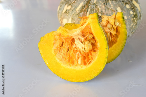Piece of pumpkin with seeds, on white background, organic vegetable