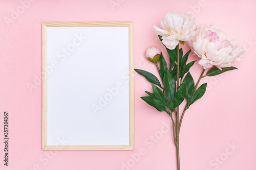 White mock up frame and pink flowers on a multi-colored background