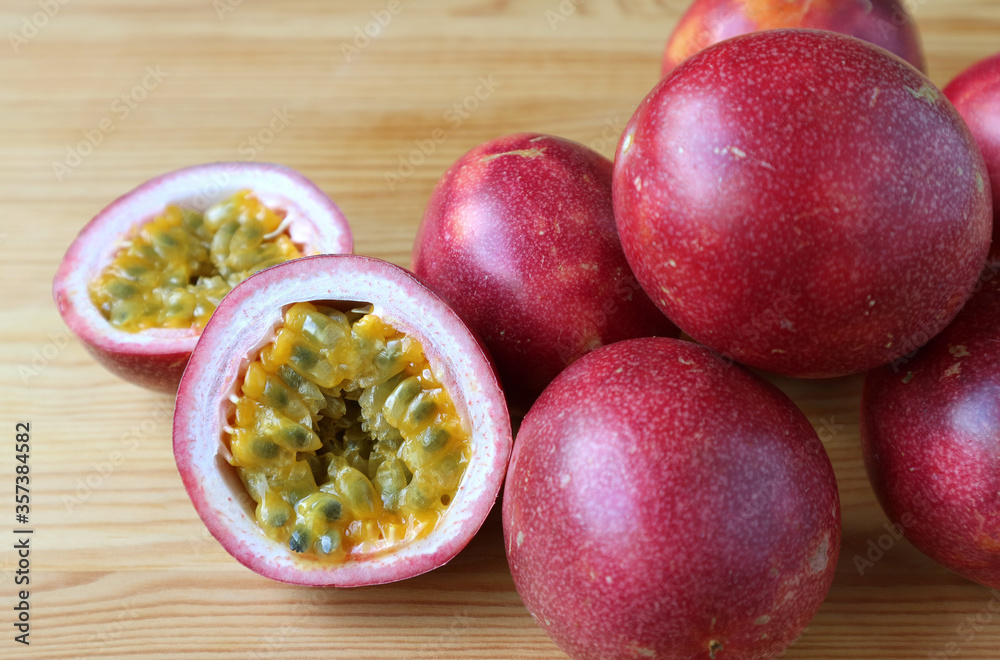 Cut in Half Fresh Ripe Passion Fruit with Pile of Whole Fruits Isolated on Wooden Table Cut in Half Fresh Ripe Passion Fruit with Pile of Whole Fruits Isolated on Wooden Table