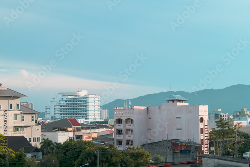 Modern business city & contemporary style building construction with green environment on beautiful sunny blue sky & mountain background at Hatyai - Thailand, free space