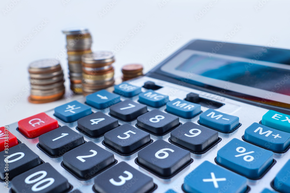 Calculator close-up on the background of coins. The investment of available funds. Deposits with interest capitalization. Calculation of future income. Consumption and accumulation. Calculator close-up on the background of coins. The investment of available funds. Deposits with interest capitalization. Calculation of future income. Consumption and accumulation.