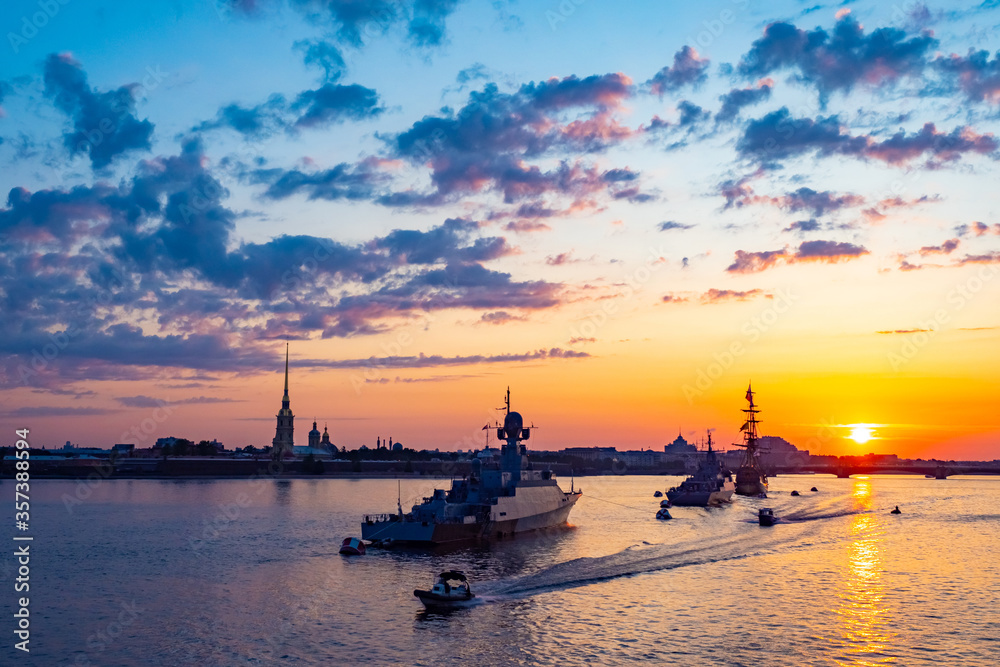Fototapeta premium Saint Petersburg. Russia. Ships and boats in the waters of the Neva. Ships and sailboat on the background of the Peter and Paul fortress. Sunset in St. Petersburg. Fleet. City of white nights.