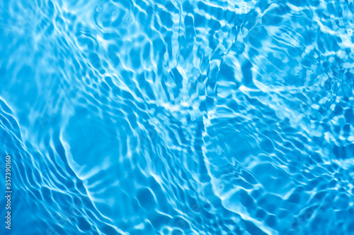 Blue splashing blue cosmetic moisturizer, micellar water, toner, or emulsion background
