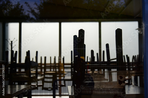 Bergamo, Italy, 01/05/2020, chairs resting on the tables of a business closed due to the lockdown