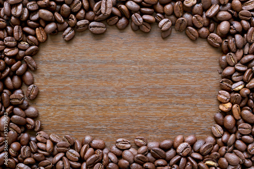 Coffee frame. A border made up of coffee beans around a wood effect background