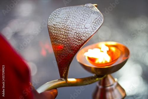 A hand offering Aarti (prayers) at river Ganga (Ganges) in Rishikesh, Uttarakhand.
