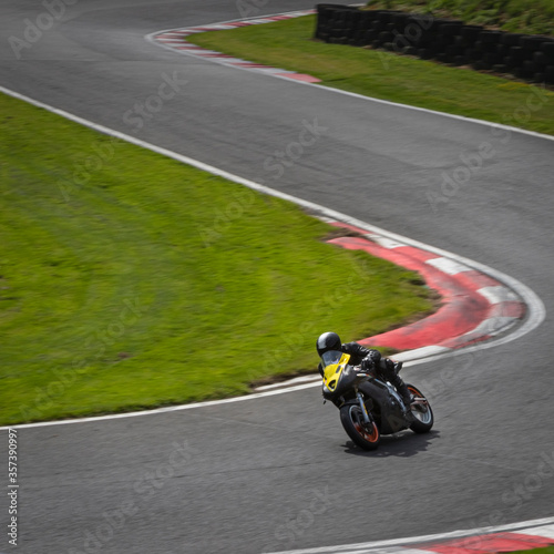 A panning shot of a black racing bike as it circuits a track