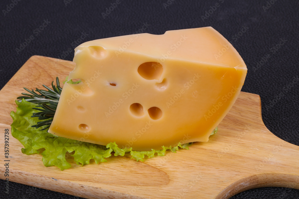 Maasdam cheese  in the board served salad leaves