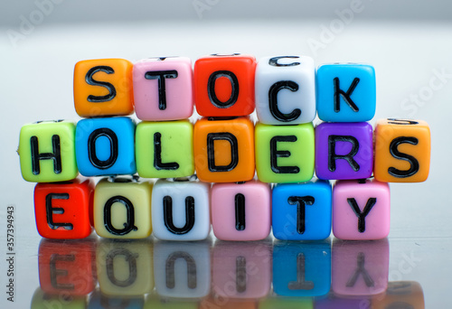 Conceptual of stockholders equity of balance sheet items financial statements spelled on colorful alphabet beads. Isolated over reflective dark background. 