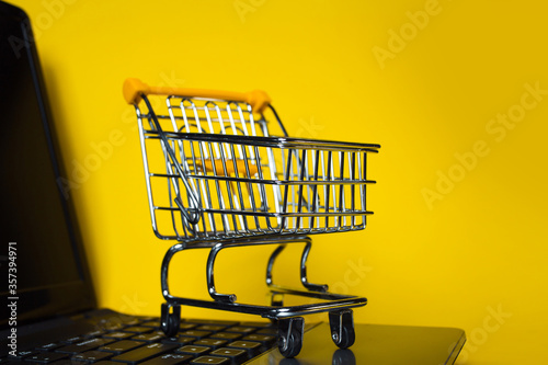End of online sales. Online shopping, shopping cart on laptop keyboard.
