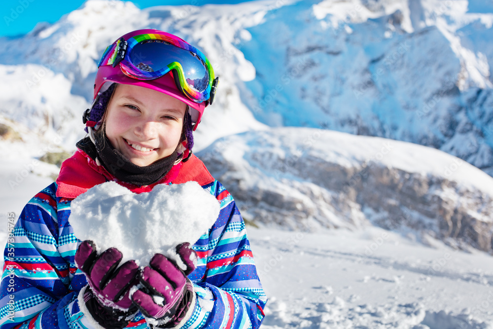 Happy young girl in winter outfit and ski googles, mask hold snow in star shape depicting love mountain vacation concept, close portrait Happy young girl in winter outfit and ski googles, mask hold snow in star shape depicting love mountain vacation concept, close portrait