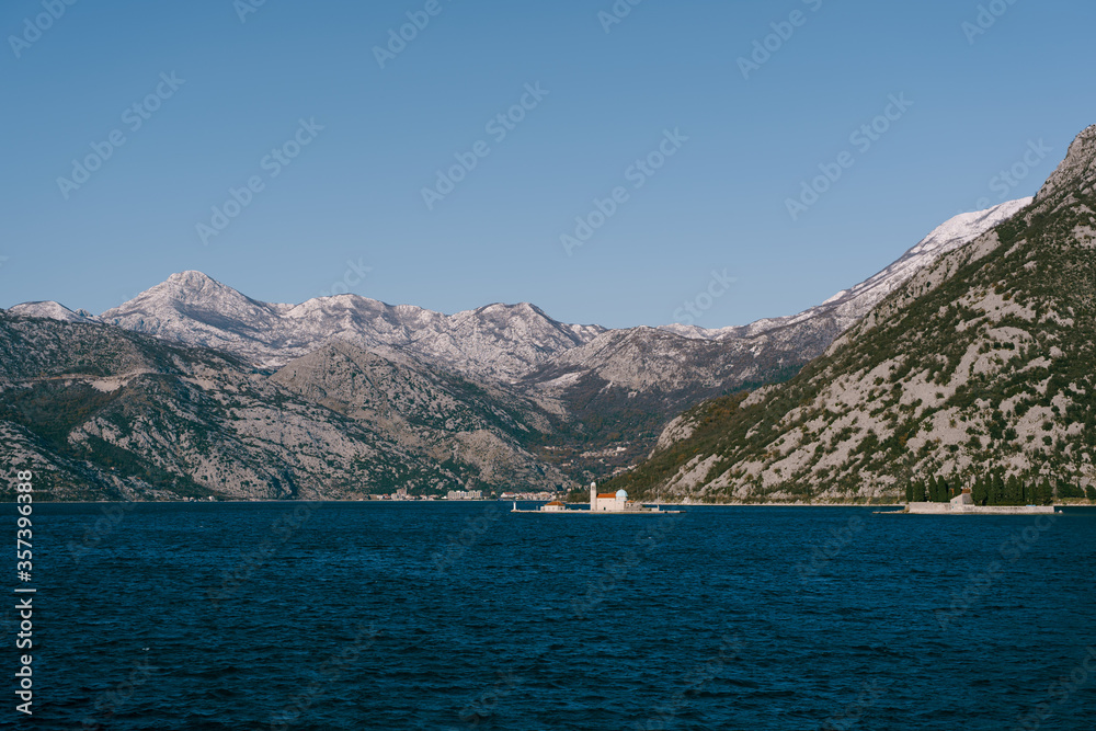 The island of St. George and the Island of Gospa od Skrpela in Kotor Bay, near Perast, Montenegro, against the backdrop of snow-capped mountains in winter.