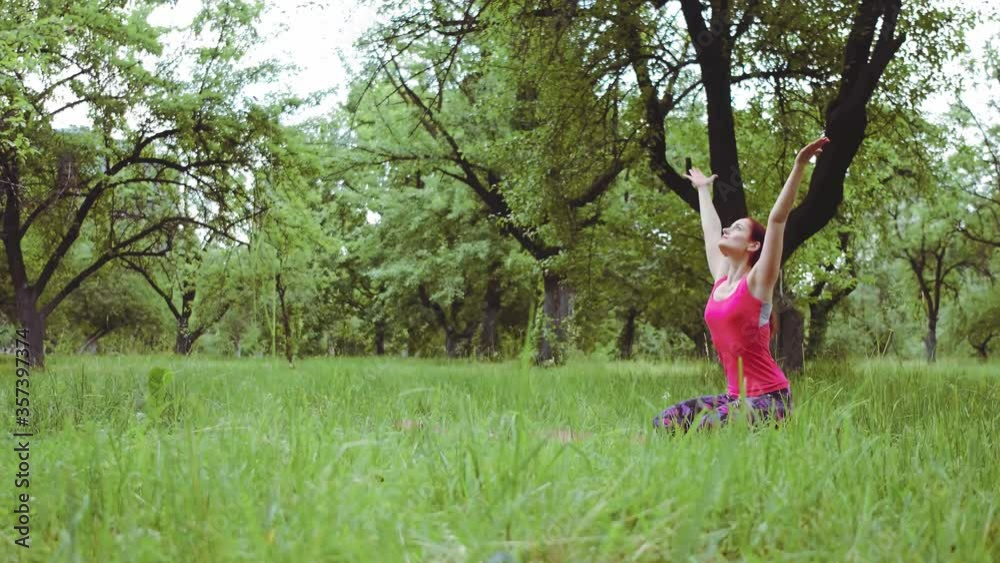 Yoga instructor girl performing breathing technique requires a lot of meditation doing exercises outdoors in the park or garden. Prores 422. Yoga instructor girl performing breathing technique requires a lot of meditation doing exercises outdoors in the park or garden. Prores 422.
