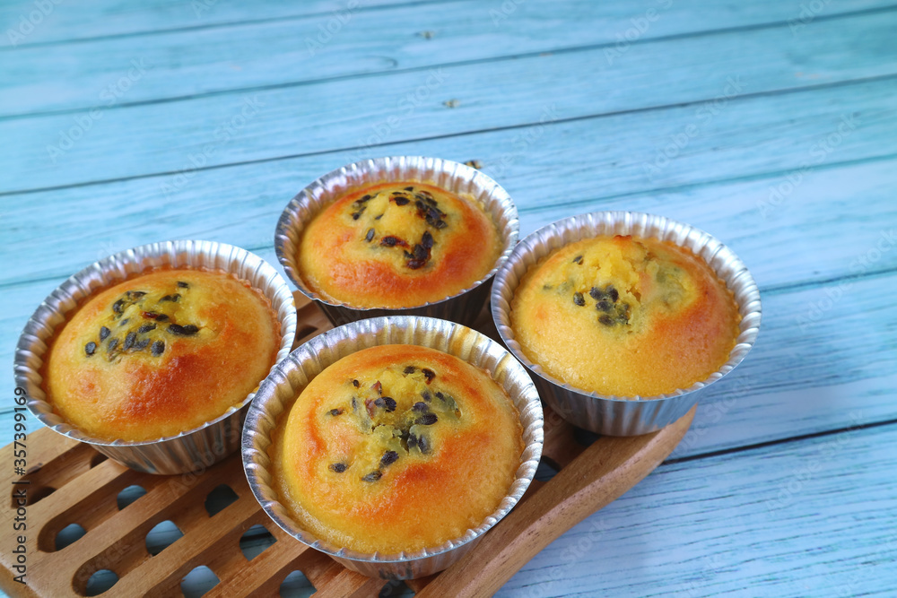 Fresh Baked Homemade Passion Fruit Muffins in Molds on Wooden Breadboard 