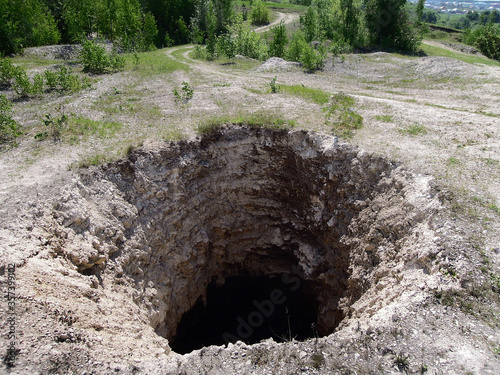 Huge karst sinkhole leading to abandoned limestone mine. Diameter of hole is about 15-18 feet, depth about 75 feet