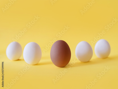 Dark and white eggs on the yellow background. Black lives matter, diversity, equal rights concept