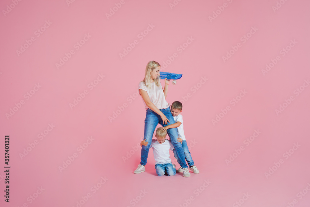 Beautiful blonde mom with two happy sons. Young woman and two baby boys,