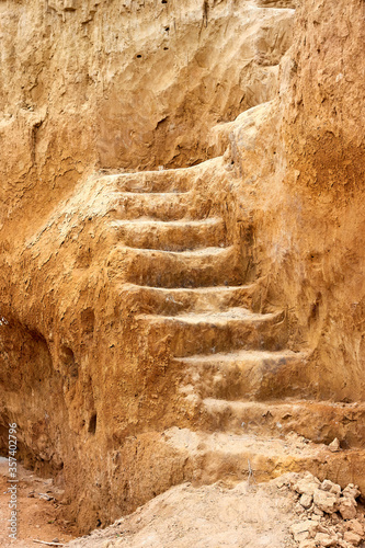 Staircase, carved in clay crag. Steep climb up srairs carved in cliff of loamy soil. photo