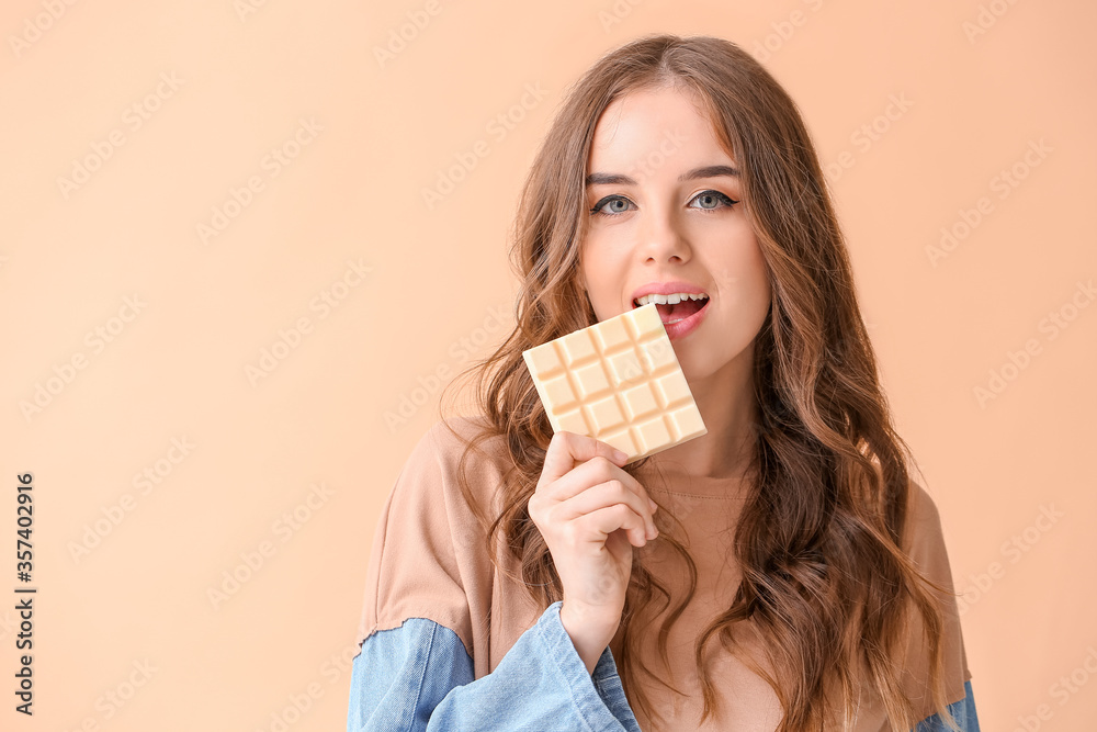 Beautiful young woman with tasty chocolate on color background Beautiful young woman with tasty chocolate on color background