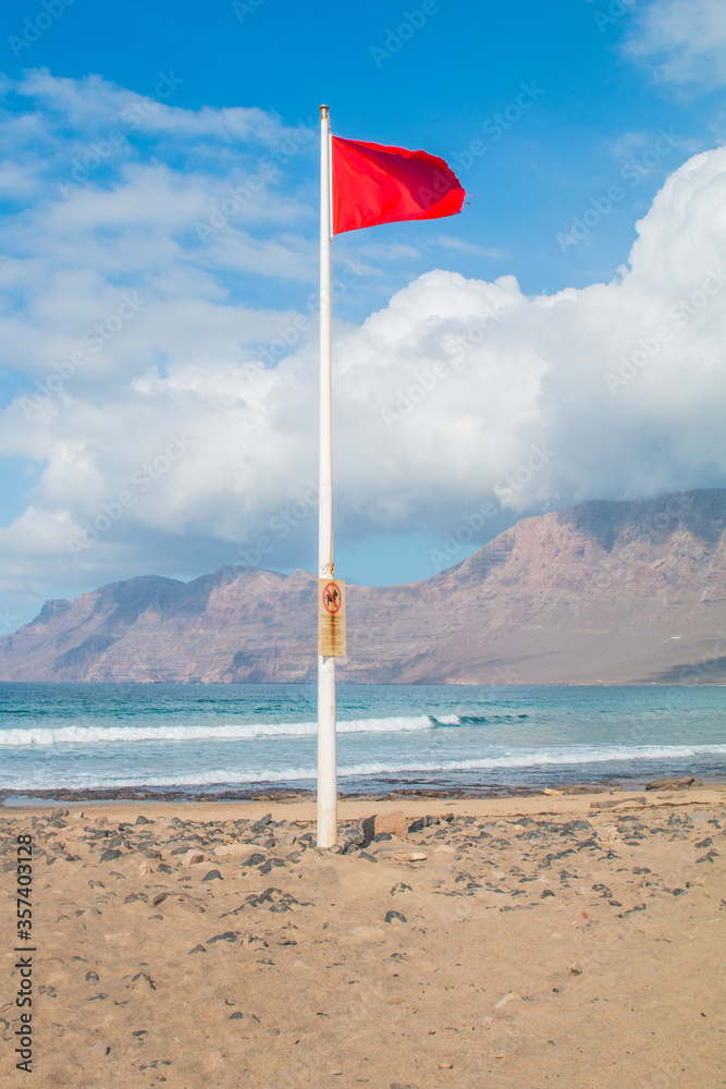 Famara Beach, popular surfing beach on coast in Lanzarote. Canary Islands. Spain. Sand dunes and people on the beach