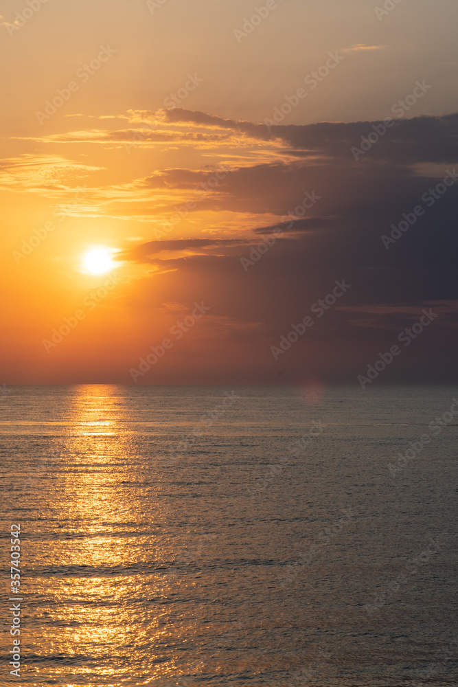 Golden sunset on the seashore. Evening Seascape, calm sea.