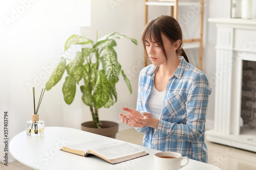 Young woman with Bible pray...