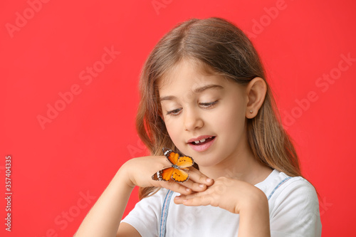 Cute little girl with butterfly on color background