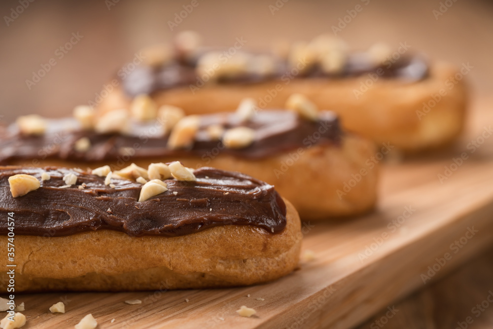 french eclairs with choclate top and hazelnuts closeup