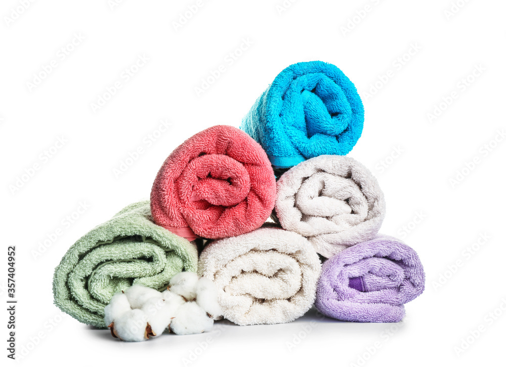 Cotton flowers and soft towels on white background