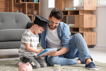 Little boy and father with savings for education at home