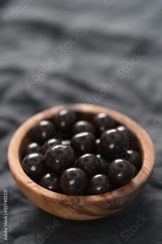 Chocolate drage with hazelnuts nuts in olive wood bowl