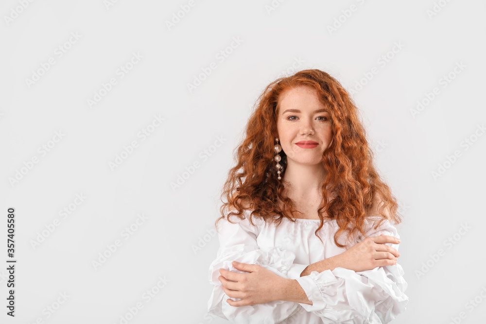 Portrait of beautiful redhead woman on light background Portrait of beautiful redhead woman on light background