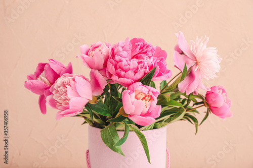 Beautiful peony flowers in vase on color background