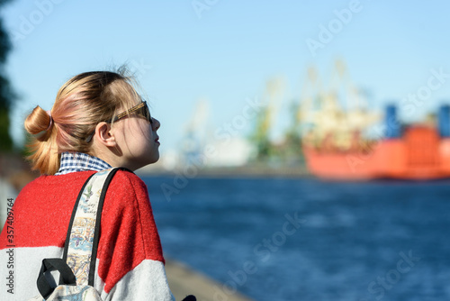 A girl alone in a commercial seaport on a walk © kulkann
