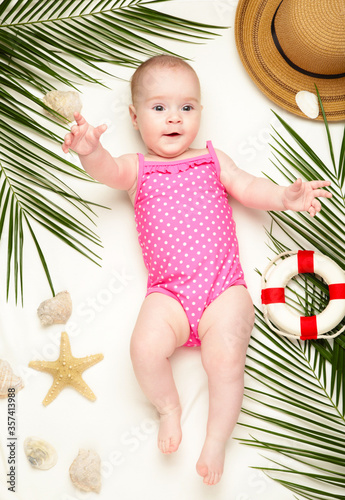 Cute baby girl with beach accessories. Holidays at sea with baby, summer concept