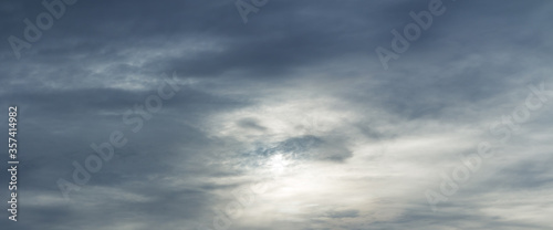 Panorama of a majestic gray sky with sun over horizon. High resolution, no birds, no noise. Sun through stormy clouds.