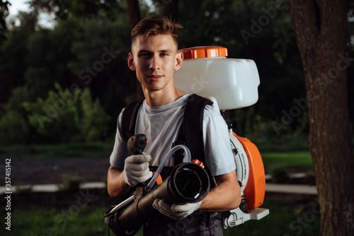 Man spraying insect repellent. Gardener with insect sprayer. photo