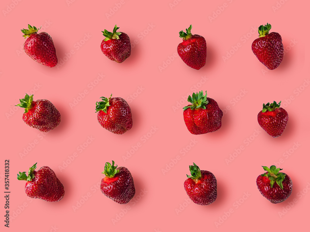 Ripe juicy red strawberries with green petals lie on a pink background. Ripe juicy red strawberries with green petals lie on a pink background.
