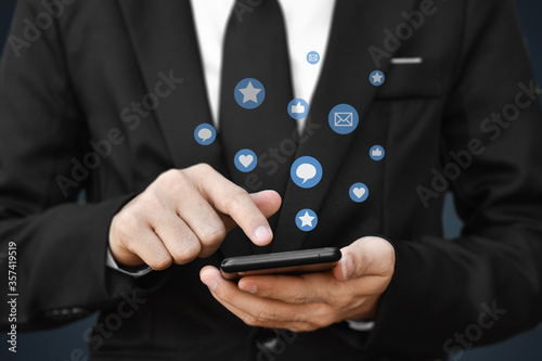 Close-up of businessman hands using mobile smartphone with social media icon. Idea for business, online marketing and technology.