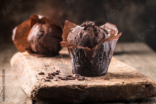 Homemade delicious chocolate muffin on wooden background close-up