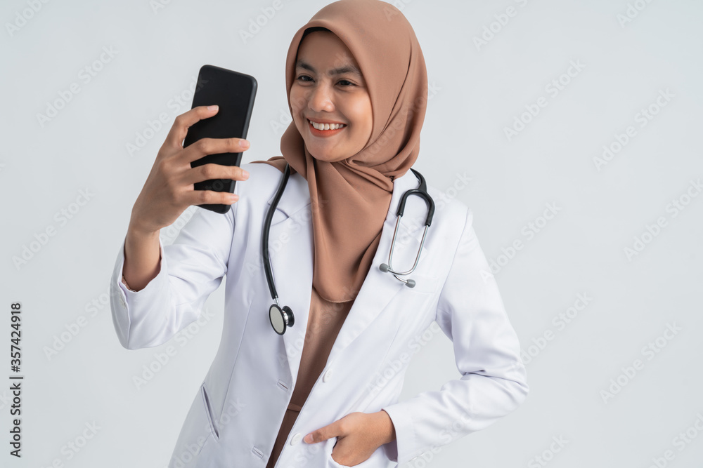 asian female doctor with hijab take selfie photo using mobile phone asian female doctor with hijab take selfie photo using mobile phone