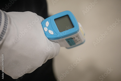 Close-up shot of digital thermometer Gun, Non-Contact Infrared Sight Handheld Forehead Readings from Coronavirus Disease 2019 (COVID-19) Epidemic virus outbreak concept