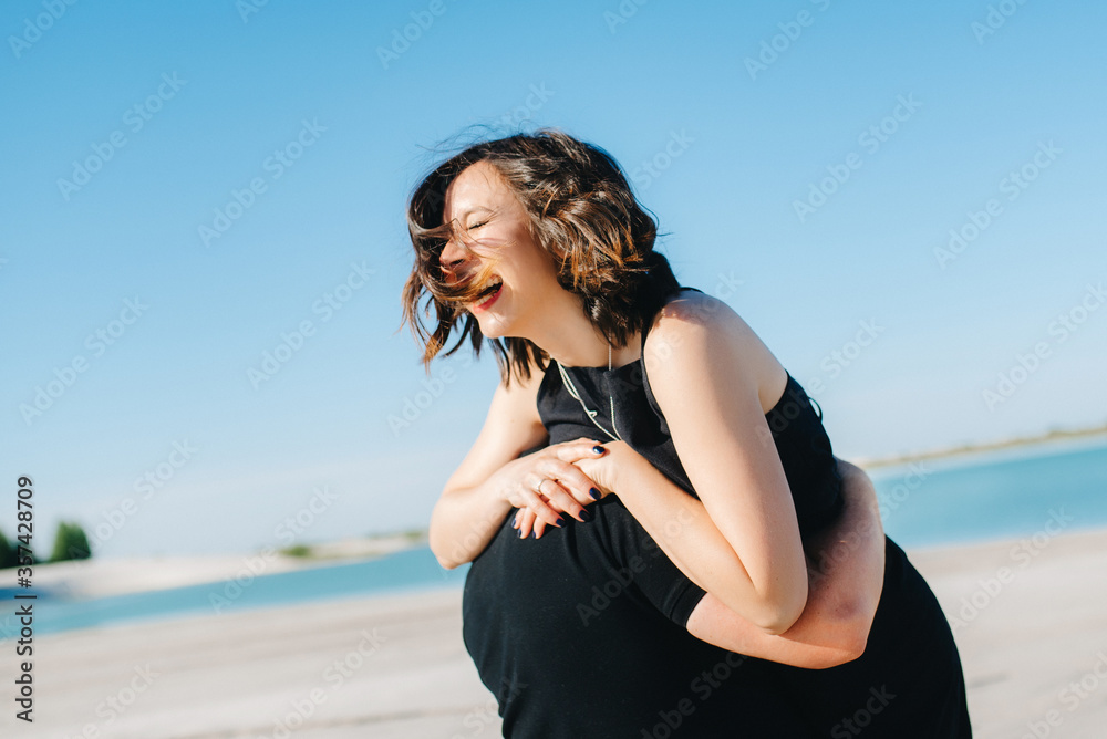 young couple a guy with a girl in black clothes are walking on the white sand young couple a guy with a girl in black clothes are walking on the white sand