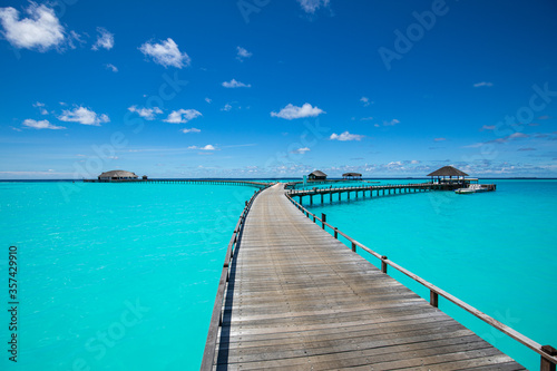 Tropical landscape of Maldives beach. Seascape panorama  luxury water villa resort with wooden pier or jetty. Luxury travel destination background for summer holiday and vacation concept.